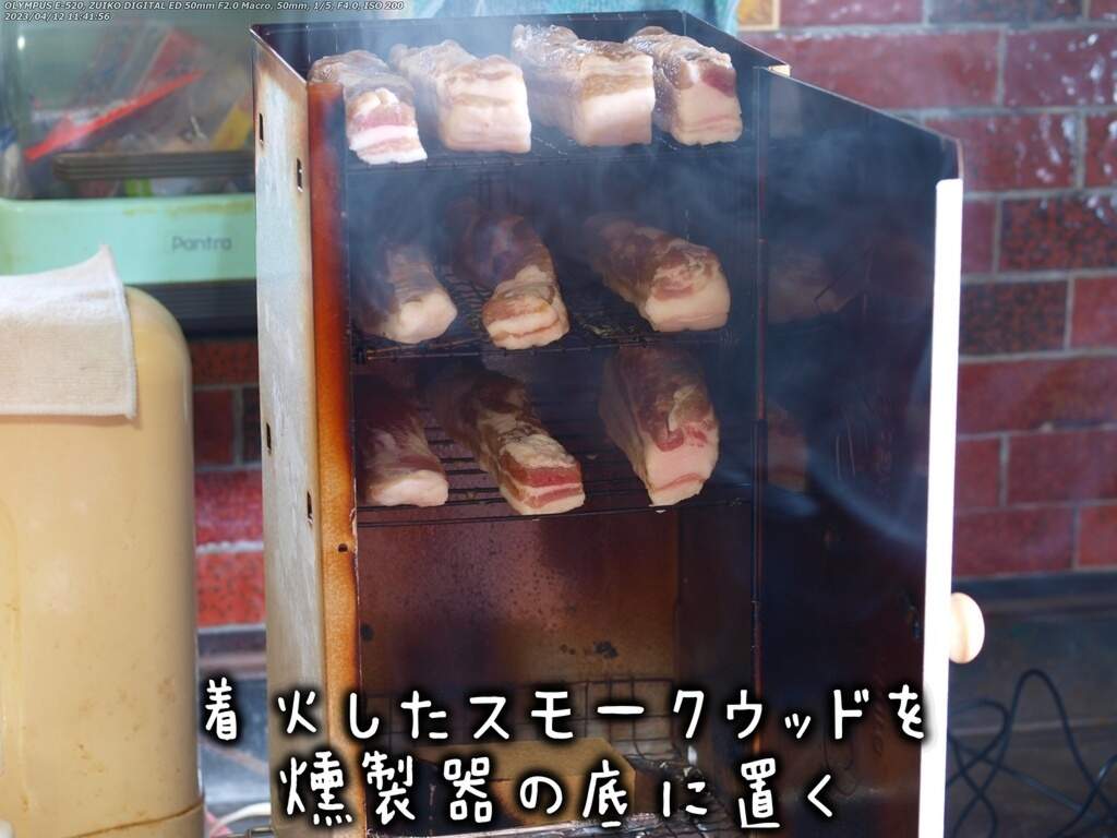 着火したスモークウッドを燻製器内にセット